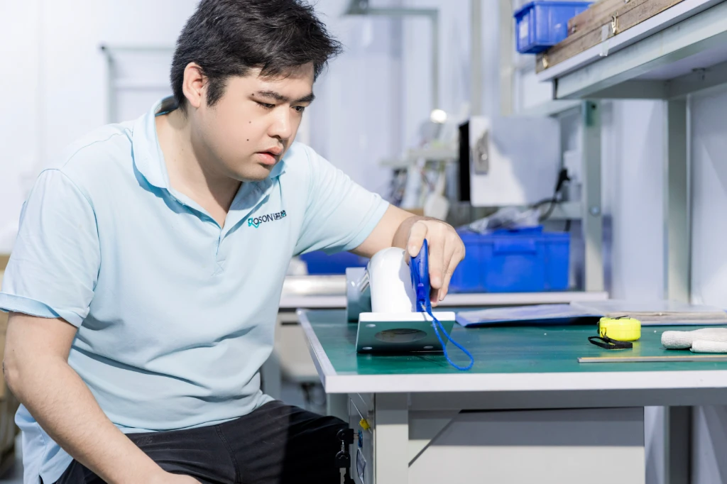 ROSON technician quality control inspection of dental equipment component during production.
