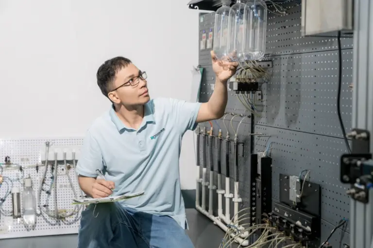 ROSON R&D team member inspecting dental product prototype with clear container.