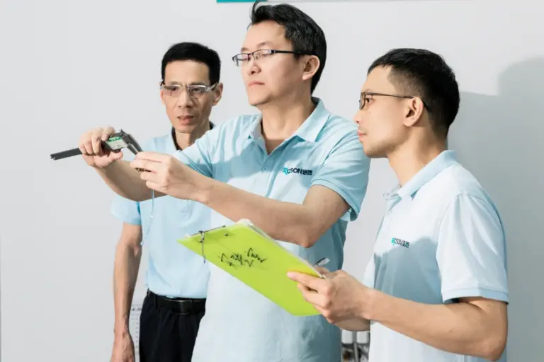 ROSON R&D team members measuring dental product component, innovation for dental practice