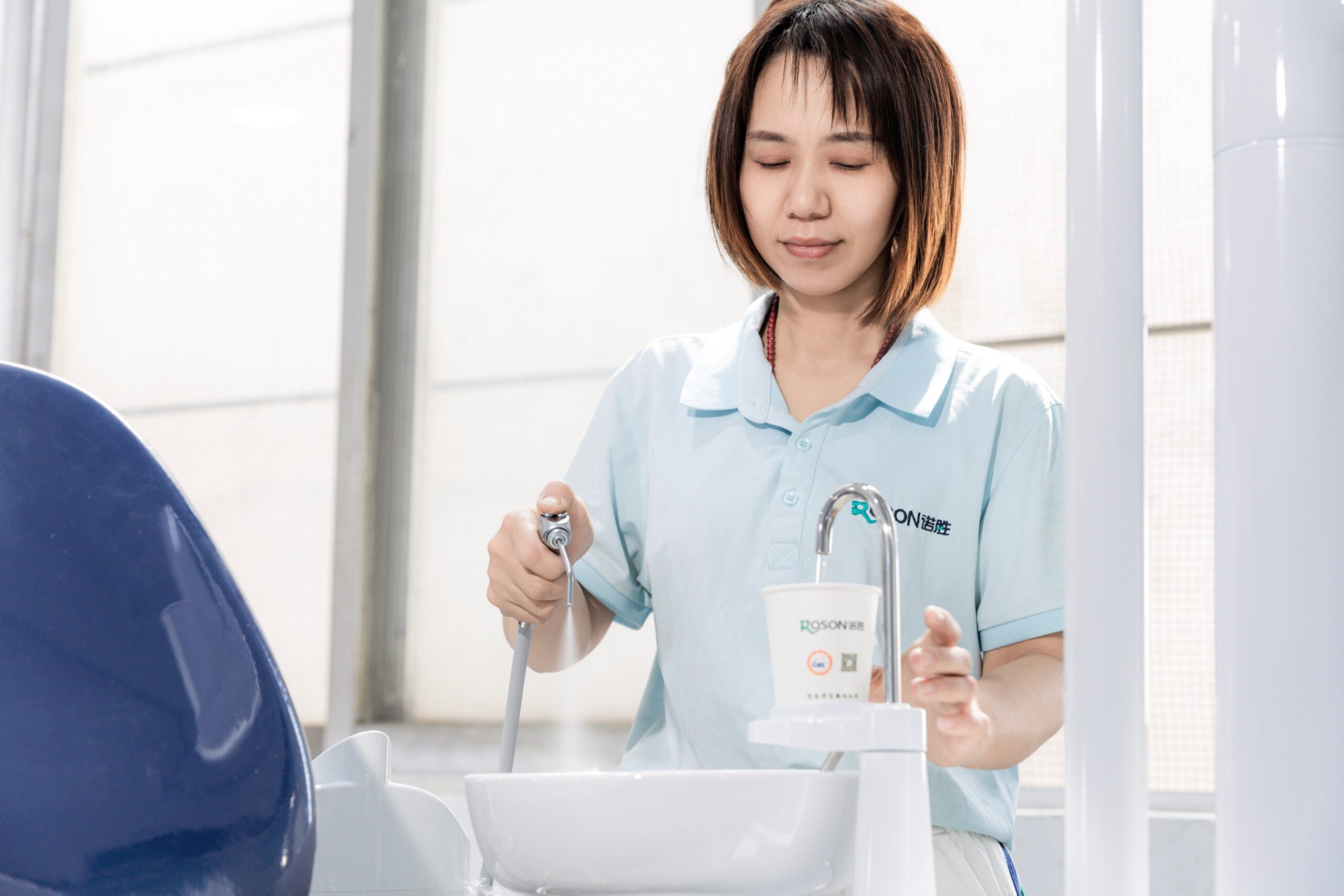 Dental assistant operating ROSON dental equipment at an affordable dental chair spittoon with air-water syringe