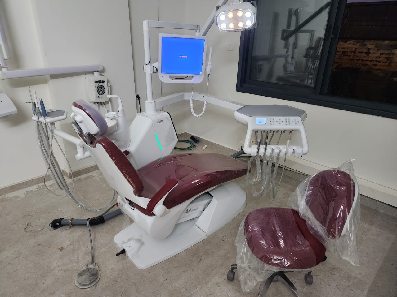 A dental technician performing routine maintenance on a dental chair's independent water bottle system.